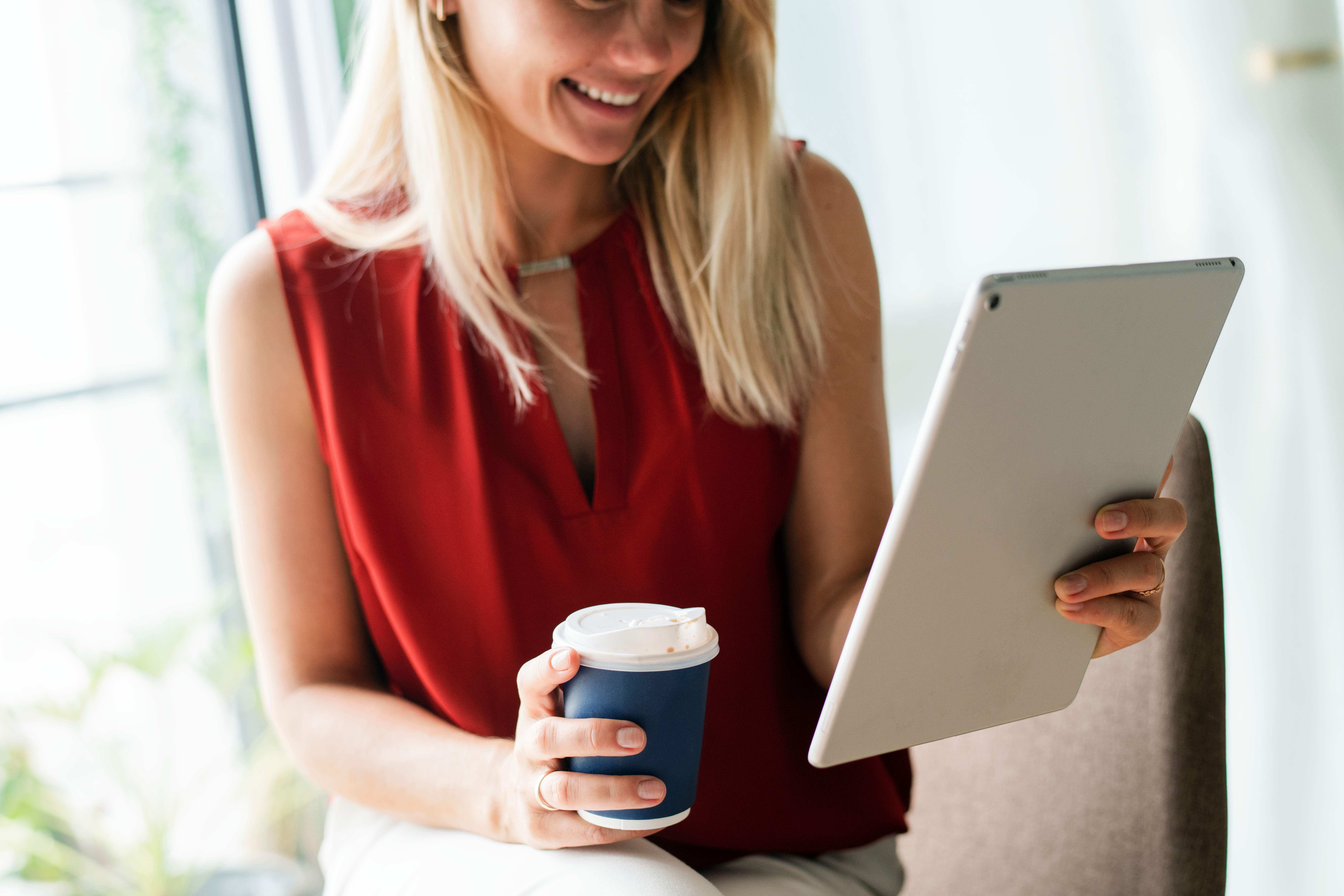 Hospitality entrepreneur reading FAQs on a tablet while enjoying coffee – easy support for hotel and restaurant listings on Hogahero.
