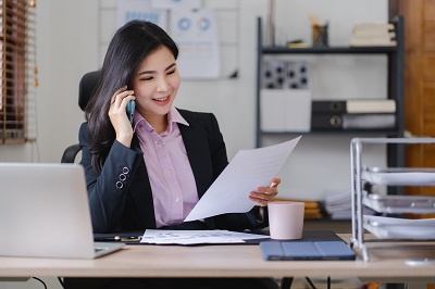 Businesswoman discussing hospitality property listing prices on the phone – transparent hotel and restaurant listing costs with Hogahero.