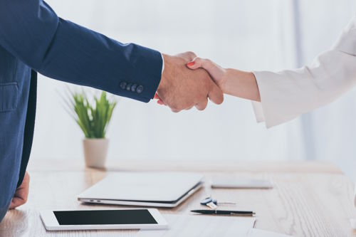 Brokers sealing a partnership with a handshake in a hospitality business setting