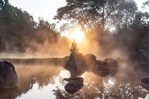 Meditation in nature at sunrise – symbol of hidden luxury, privacy and wellness in hospitality